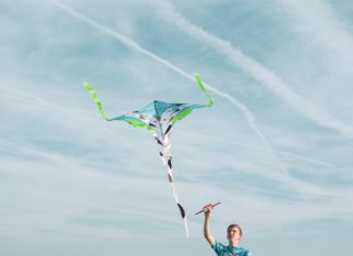 En drage kan være et sjovt hobbyprojekt for dig og dit barn Mand holder fast i flyvende drage