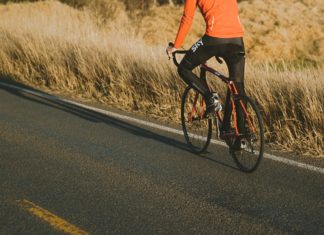 Kom i gang med din hobby igen, hvis smerter har forhindret dig Person cykler op ad bakke på racercykel